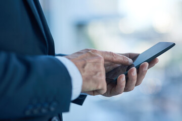 Success is all about making the right connections. Closeup shot of a businessman texting on a...