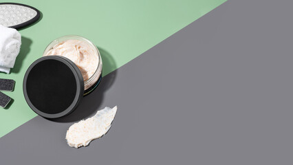 A jar of foot scrub with softening effect on a green and gray background. Set of SPA cosmetic products. Foot scrub, a natural cosmetic. Cosmetic product for peeling and spa care. Selfcare. Copy space