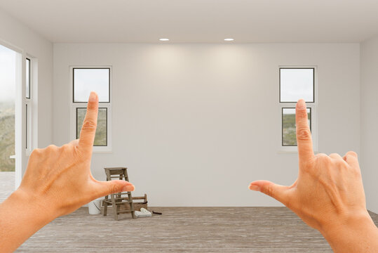 Female Hands Framing Blank Unfinisehd Walls in Empty Room of House.