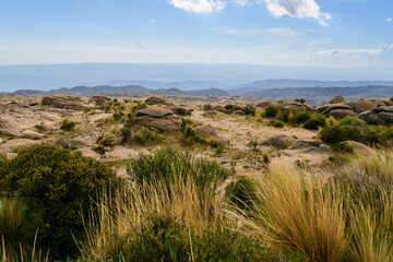 Paisaje desértico de estepa con vegetación y fondo de montañas con cielo y nubes