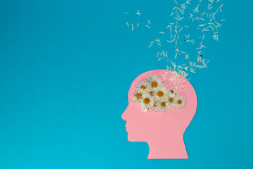 
pink paper head on a blue background, instead of a daisy brain whose petals flew all around,...