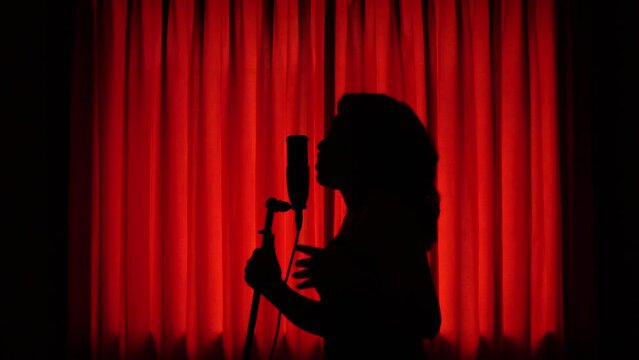 Mujer joven disfrutando del canto. Mujer cantando en estudio.