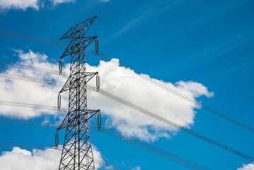 High voltage pole power transmission tower with clear sky sunny day background. Green energy,...