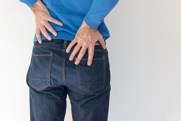 Long working hours and health. Mature man with back or kidney pain clutching his back.