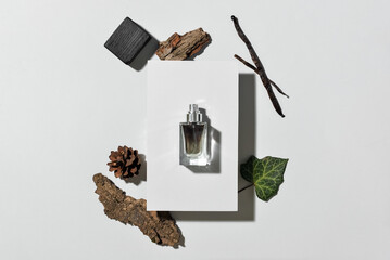 Bottle of woody perfume on light background, top view