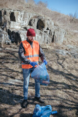 volunteer cleaner is cleaning up park and standing by bunch of garbage