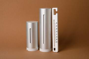 Digital weather station and thermometer on color background