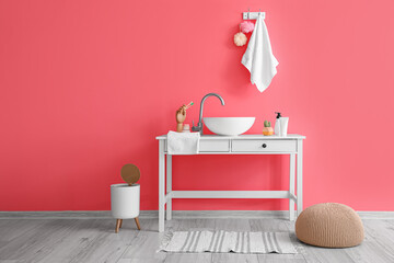 Interior of stylish bathroom with sink and pouf