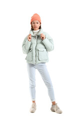 Pretty young woman in stylish warm clothes on white background