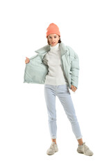 Pretty young woman in stylish warm clothes on white background