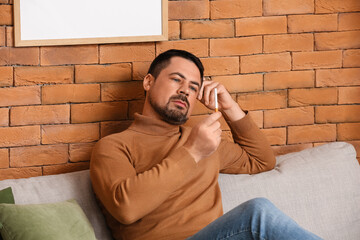 Thoughtful man with cigarette at home. Concept of refusing from bad habit