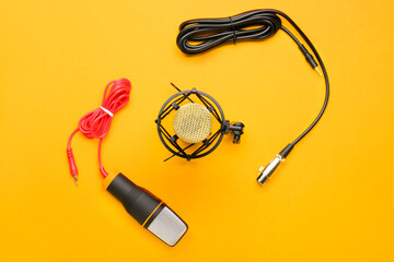 Fototapeta premium Audio production and podcasting equipment, microphones and cables on orange background