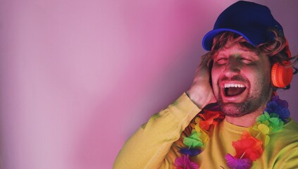 Young adult listening to good music via headset while standing with eyes closed , wearing Hawaiian...