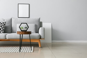 Interior of modern living room with stylish sofa, table and photo frame