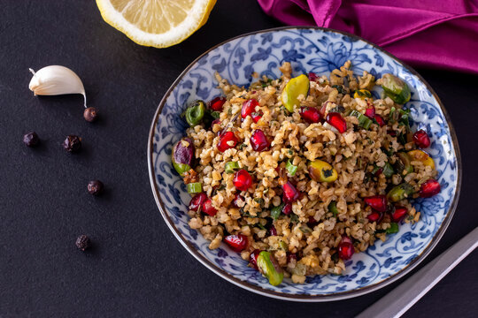 Freekeh, pomegranate seeds and pistachio healthy salad. Arabic, African and Arabic traditional cuisine. Copy space. Superfood concept.