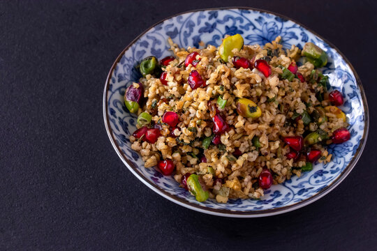 Freekeh, pomegranate seeds and pistachio healthy salad. Arabic, African and Arabic traditional cuisine. Copy space. Superfood concept.