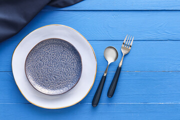 Elegant table setting on blue wooden background