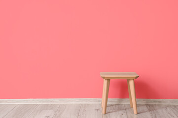 Wooden table near color wall in room interior