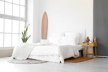 Interior of modern bedroom with wooden surfboard and table