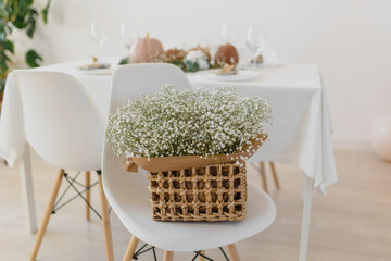 Decoration in boho style. Pumpkins on the table with eucalyptus and gypsophila. Stylish table decoration for the event. Gypsophila in a basket