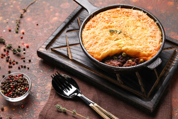 Frying pan with tasty Shepherd's pie on grunge background