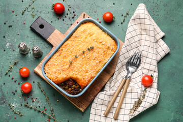 Baking dish with tasty Shepherd's pie on green background