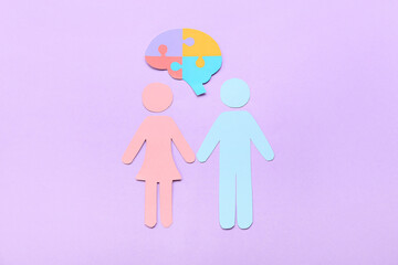 Paper human figures with puzzle pieces on lilac background. Concept of autistic disorder