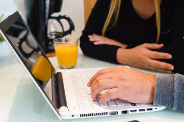 closeup of male hand typing on white laptop keyboard at home