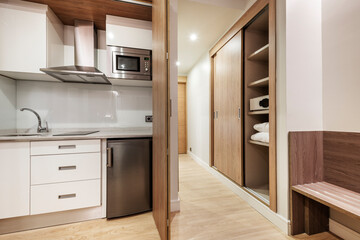 hotel room with french kitchen with wooden doors and safe inside a closet with sliding wooden doors
