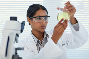 Focused on solving medical mysteries. Cropped shot of a young female scientist conducting an experiment in a lab.