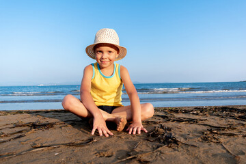 Portrait of a cute child sitting on a rocks near the sea.