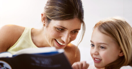 We share a similar love for books. Shot of a beautiful young mother reading a book with her daughter at home.