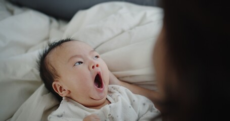Close up adorable newborn baby infant child girl Yawning on the bed in the morning at home, family, children, parenthood, childhood, life, love concept	
