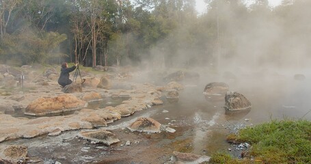 Tourist traveler woman taking photo landscape nature hot spring water Onsen Natural Bath with fog mist in the morning sunrise at Chae Son National Park, Lampang Thailand	
