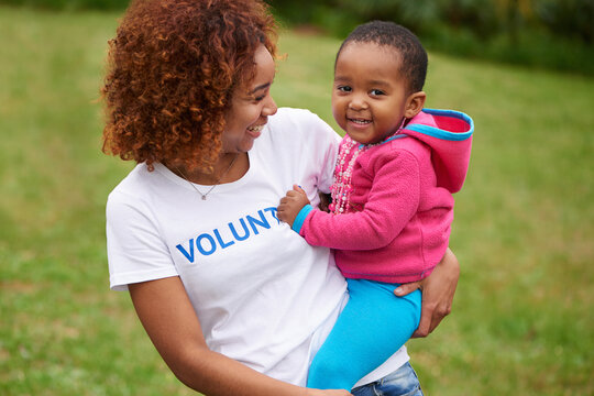 Work for a cause, not applause. Shot of volunteers working with little children.