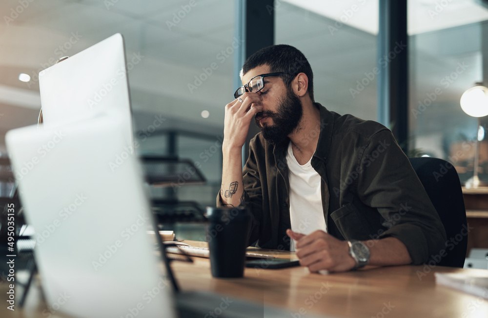Poster how many more nights of this can i take. shot of a young businessman feeling stressed while working 