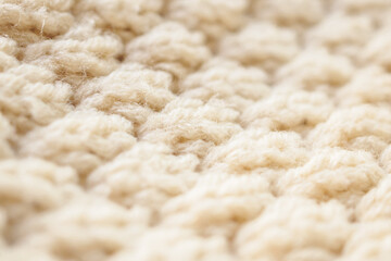 closeup beige knitted woolen fabric texture background