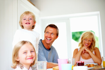 Obraz na płótnie Canvas Happy family having their breakfast together at home. Portrait of a happy family having their breakfast together at home.