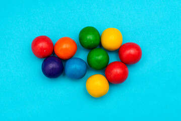 Colorful round chewing gums on blue background.