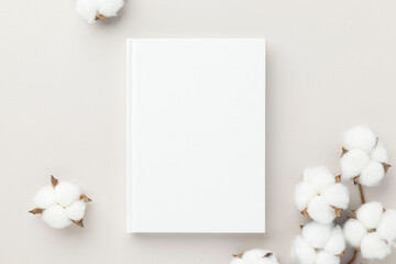 White book blank cover mockup on a beige background with cotton flower, flat lay, mockup