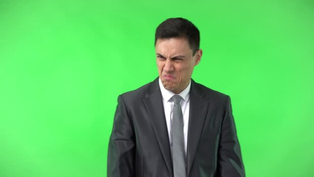 Elegant man with disgusted face in studio