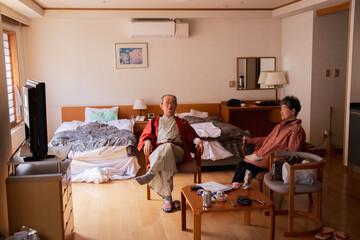 Old asian couple relaxing in ryokan hotel room in Japan