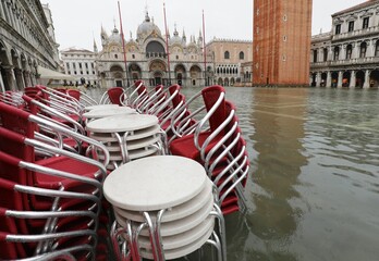chairs and tables of an outdoor bar in Saint Mark Square in Venice in Italy during the flooding...