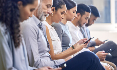 Its not a distraction Its an important tool. Cropped shot of a group of businesspeople using their cellphones while sitting in the office during a conference.