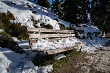 Wooden bench with snow for resting hikers in the mountains
