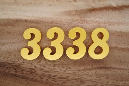 Golden Arabic numerals on a real brown and white wooden floor number 3338