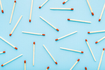 Match sticks on light blue table. Pastel color. Pattern background. Closeup. Top down view.