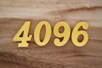 Golden Arabic numerals on a real brown and white wooden floor number 4096