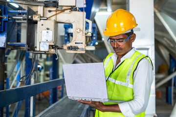 industrial worker busy using laptop at workplace - concept of technology, safety and maintenance...
