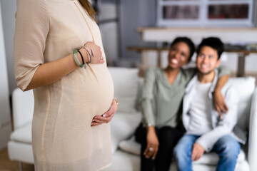 Pregnant Woman Touching Her Belly's Woman Standing In Front